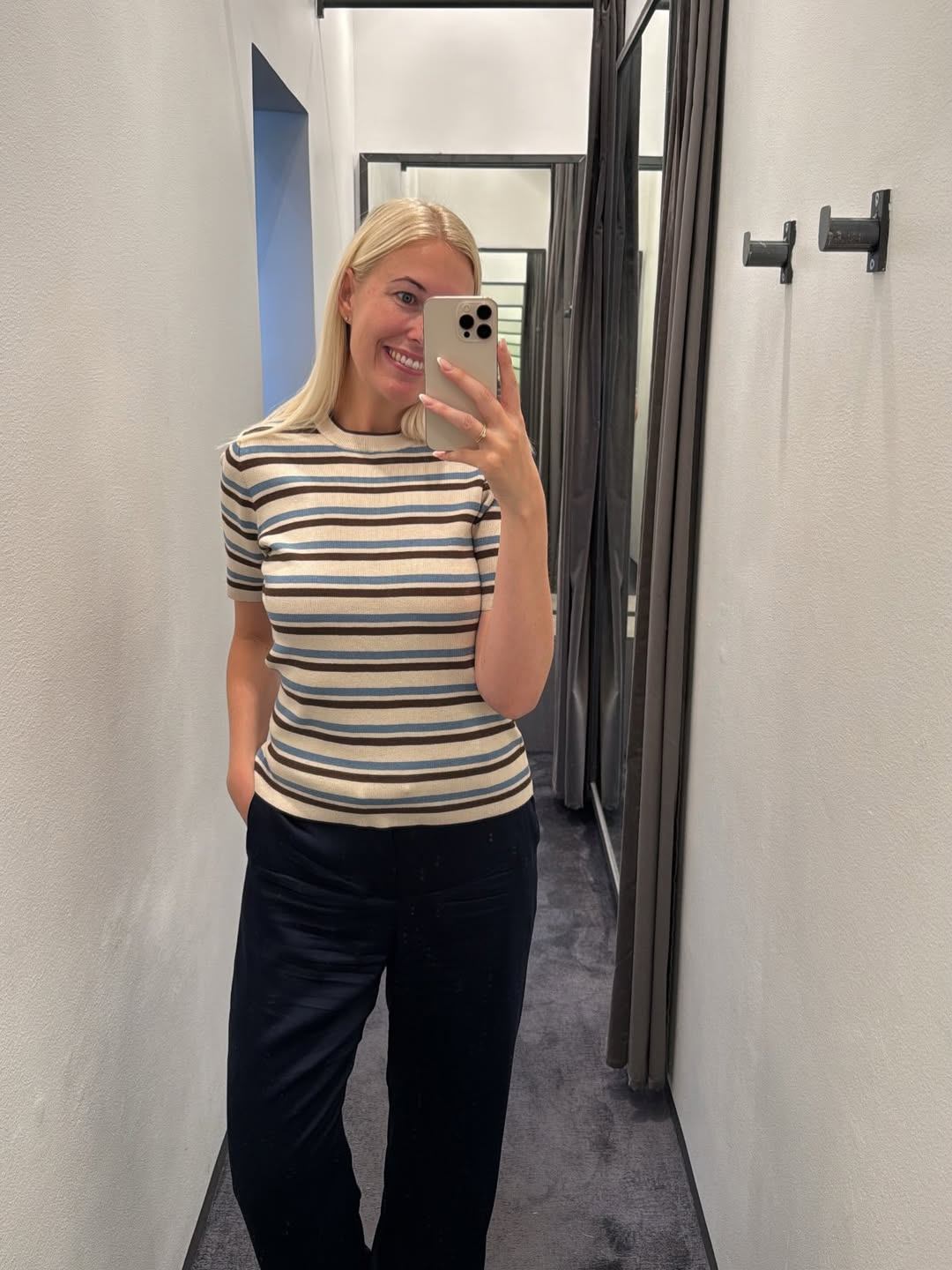 Stribet strikbluse i creme, brun og blå med mørkeblå bukser
